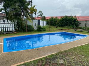 a large blue swimming pool in a yard at La villa June by Juniar Place in Kampong Ulu Pegoh