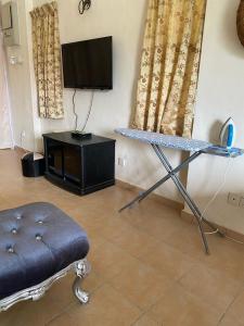 a living room with a table and a tv at La villa June by Juniar Place in Kampong Ulu Pegoh
