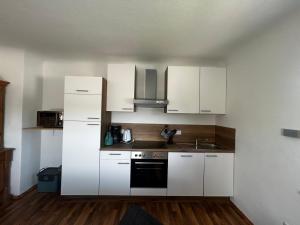 a kitchen with white cabinets and a stove top oven at Ferienwohnung Moselnest in Piesport