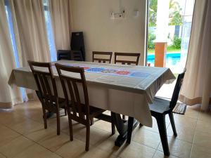 a dining room table with chairs and a tablecloth on it at La villa June by Juniar Place in Kampong Ulu Pegoh
