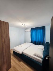 a bedroom with a bed with a blue curtain at Charshiq Guest House in Veliko Tŭrnovo