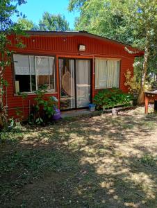 a red house with windows and a yard at Cisnes del tolten in Freire