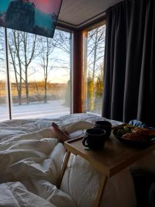 a bed with a table with a plate of food on it at KotkaPesa in Vihtra