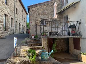 a stone building with a balcony on a street at Maisonnette ardéchoise au centre du village in Nozières