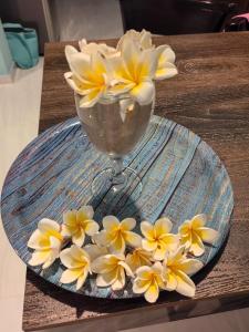 a plate with yellow and white flowers on a table at The Shore Residence in Hikkaduwa