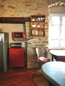 a kitchen with a red refrigerator and a microwave at Gite rustique de charme chez Santa é Pasquà in San-Martino-di-Lota