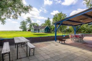 a patio with tables and chairs and a house at Olle Hansenhaus in Hantumeruitburen
