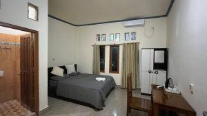 a bedroom with a bed and a refrigerator in it at Chik Nories in Labuan Bajo