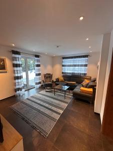 a living room with a couch and a table at Chalet Ausweger - Strobl am Wolfgangsee in Strobl