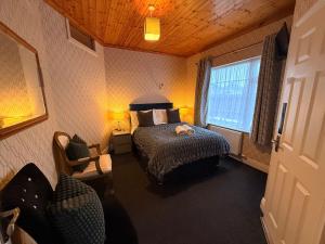 a bedroom with a bed and a chair and a window at St Anthonys B&B in Dungarvan +25 photos