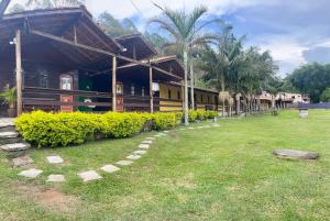 a building with a grass yard in front of it at POUSADA HARAS K&k in Pinhalzinho