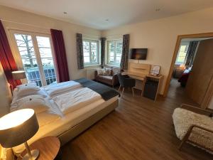 a bedroom with a bed and a desk with a chair at Seeberger Haus B&B in Sankt Anton am Arlberg +48 photos