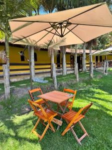 a table and chairs under a large umbrella at POUSADA HARAS K&k in Pinhalzinho +7 photos