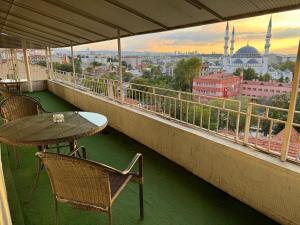 a balcony with a table and chairs and a view of a city at Ankara Efes Otel in Altındağ