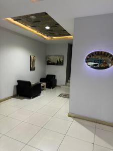 a waiting room with black chairs and a ceiling at Ankara Efes Otel in Altındağ
