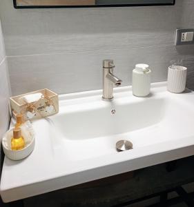 a white bathroom sink with a chrome faucet at Archè apartment AGRIGENTO in Agrigento