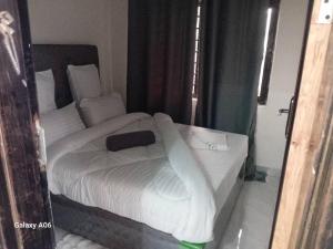a bedroom with a bed with white sheets and pillows at Wamis serviced apartments in Solwezi
