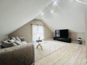 a living room with a couch and a flat screen tv at Spacious home in quiet surroundings in Schwanden +2 photos