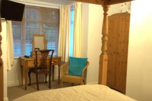 a bedroom with a desk and a table with a chair at Walcot House in Fawley