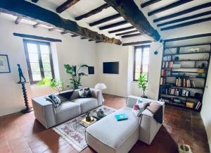 a living room with two couches and a book shelf at La Hurre in Montiron