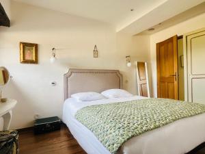 a bedroom with a large bed with white sheets at La Hurre in Montiron