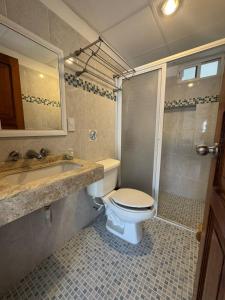 a bathroom with a toilet and a sink and a shower at Calma Chicha Rooms in Playa del Carmen +81 photos