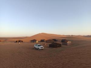 a truck parked in the middle of a desert at Authentic Sahara with Locals in Tagounite