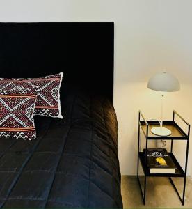 a bedroom with a bed and a table with a lamp at Österlen, Solhögs Gård nr 2 in Hammenhög