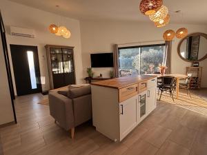a kitchen and living room with a couch and a table at Domaine Hestia in Robion en Luberon