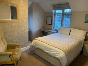 a bedroom with a bed and a chair and a window at Walcot House in Fawley