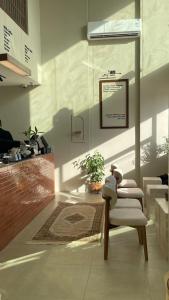 a living room with a chair and a picture on the wall at فندق مساكن الجود in Al ‘Azīzīyah
