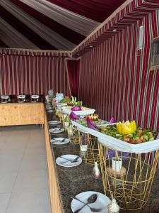 a row of tables with plates of food on them at Madonna Rum camp bubbles & Jeep tours in Wadi Rum