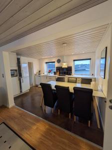 a kitchen and dining room with a table and chairs at Hus 5 personer in Hjørring