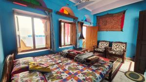 Ein Schlafzimmer mit einem Bett in einem Zimmer mit blauen Wänden in der Unterkunft Hotel Paramount Palace in Pushkar + 49 Fotos