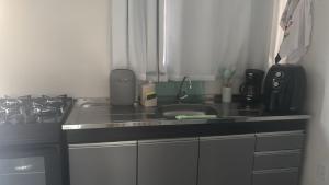 a kitchen counter with a sink and a stove at Casa da Praia Bem Viver in Santa Cruz Cabrália