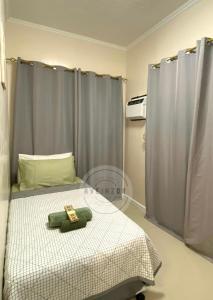 a bedroom with a bed with a teddy bear on it at Cozy Home in Dipolog by Aveinz in Dipolog