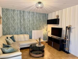 a living room with a couch and a tv at Ferienwohnung Luna in Eppelborn