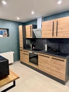 a kitchen with wooden cabinets and a stove top oven at Ferienwohnung Luna in Eppelborn
