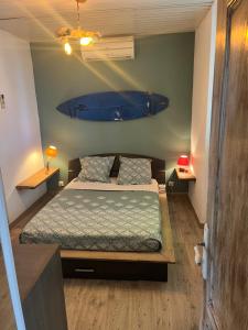 a bedroom with a bed and a blue surfboard on the wall at Location 6 personnes patrimonio in Patrimonio