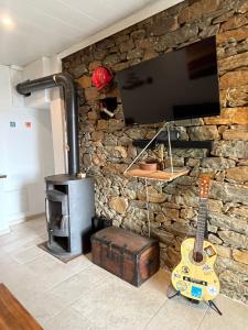 a stone wall with a tv and a guitar on it at Location 6 personnes patrimonio in Patrimonio