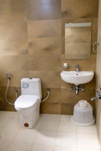 a bathroom with a toilet and a sink at Hotel Sakura Inn in Hosūr