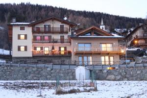 a large house with a stone wall in the snow at CAV MES VALLEES Torgnon Vda in Torgnon +67 photos