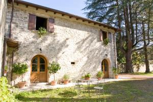 a building with a table and chairs in front of it at La Casetta di Giovanni in Pratovecchio