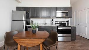 a kitchen with a table with chairs and a refrigerator at Landing Amazing Studio Gym in Spartanburg