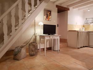 a living room with a table with a television on it at Prouyssou in Beauville