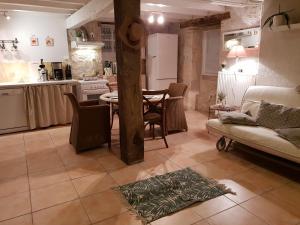 a kitchen and living room with a couch and a table at Prouyssou in Beauville