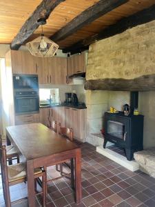 a kitchen with a wooden table and a stove at La Fontaine du Peuch in Plazac