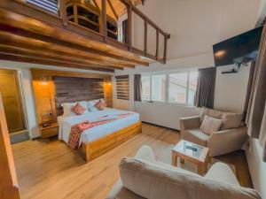 a bedroom with a bed and a living room with a couch at Queens Lake Cabin in Nuwara Eliya +51 photos