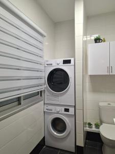 a washing machine in a bathroom next to a toilet at Histadrout street 3 bedrooms central Ashdod in Ashdod