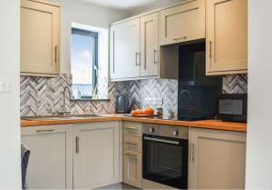 a kitchen with white cabinets and a counter top at Pentarow Barn in Falmouth